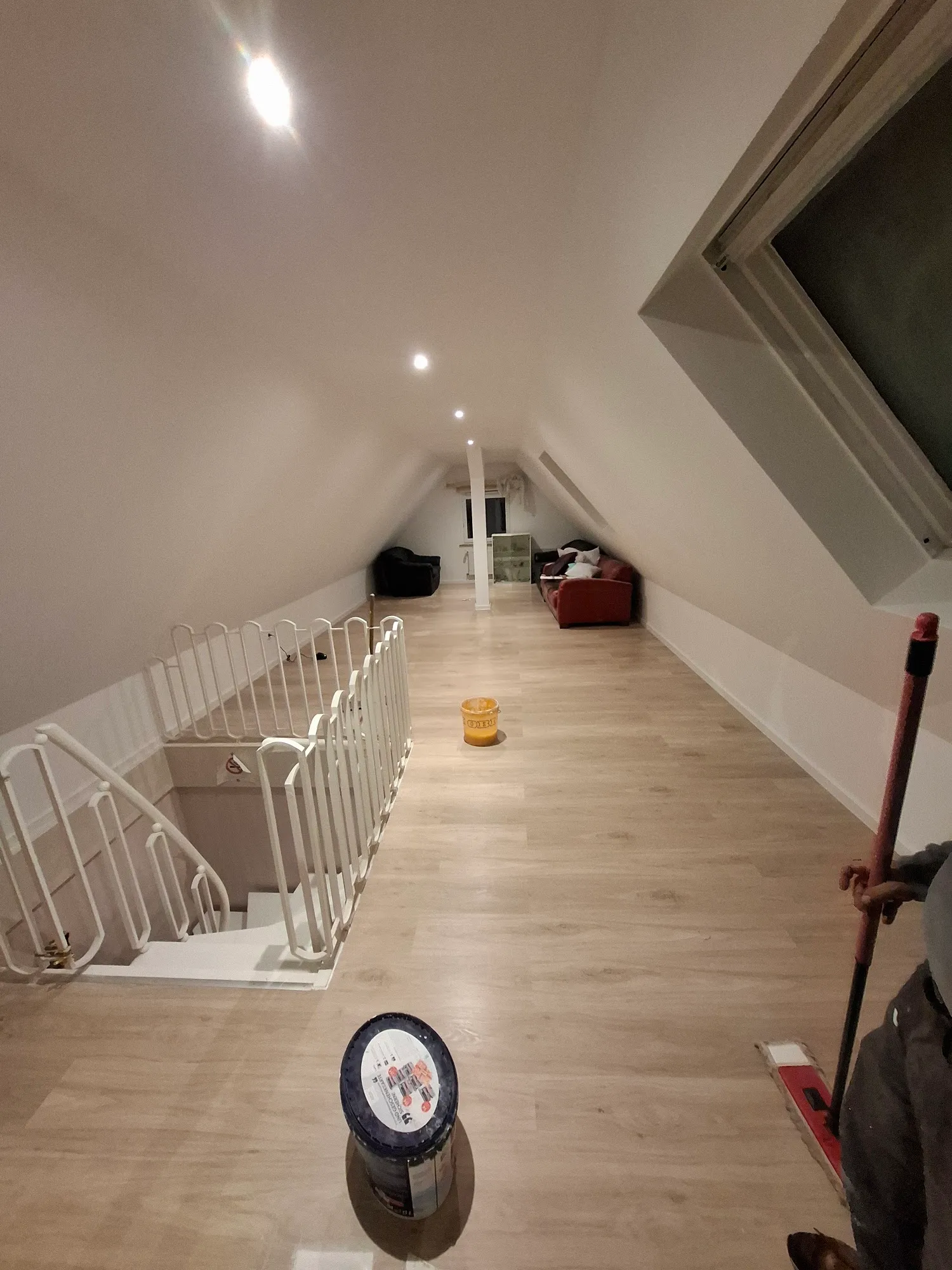 Ausgebautes Dachgeschoss mit hellem Laminat und weißem Geländer